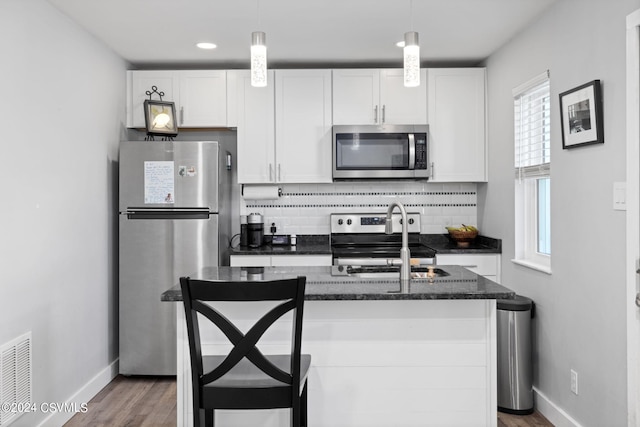 kitchen featuring a wealth of natural light, appliances with stainless steel finishes, and white cabinetry