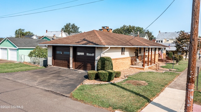 ranch-style home featuring an outbuilding, a front yard, a garage, and a porch