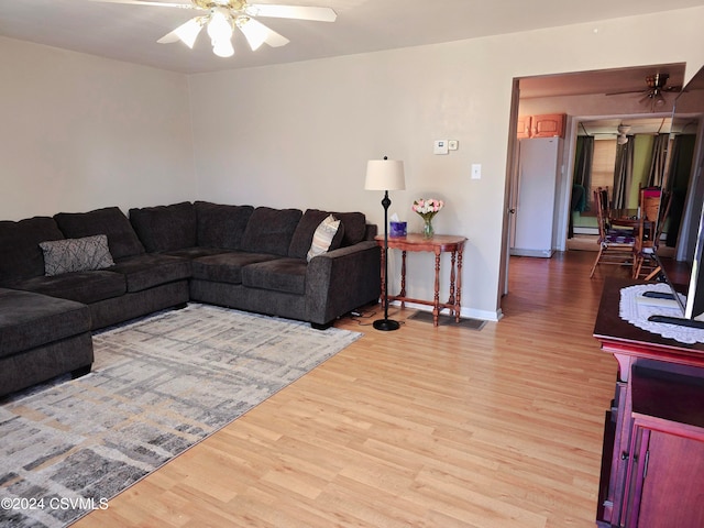 living room featuring ceiling fan and light hardwood / wood-style floors