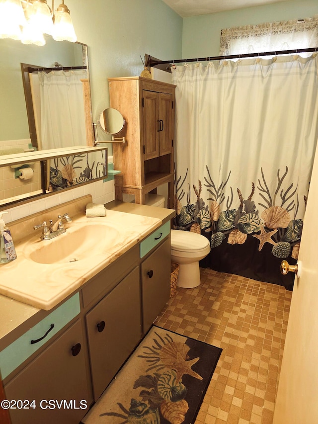 bathroom with vanity, toilet, curtained shower, and tasteful backsplash