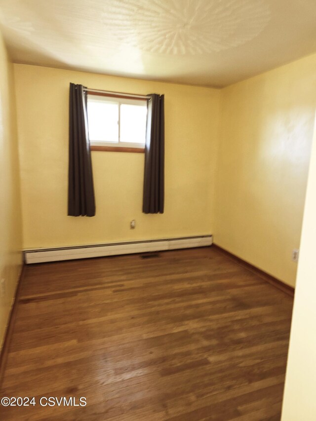 1000 E 6th St, Berwick, PA 18603 - unfurnished room with baseboards, wood finished floors, and baseboard heating