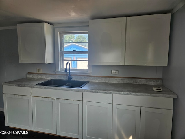 kitchen with wood-type flooring, sink, and white cabinets