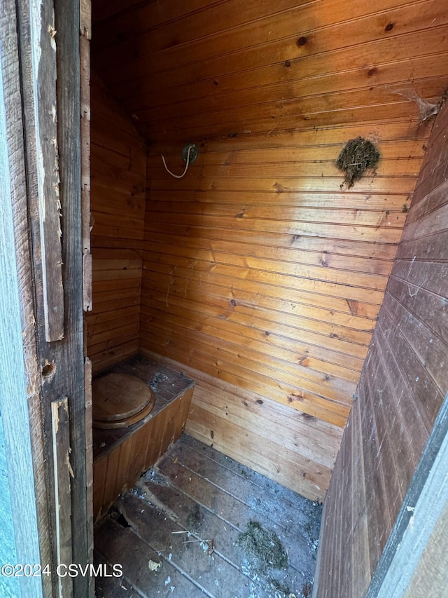 bathroom featuring wooden ceiling, vaulted ceiling, and wooden walls