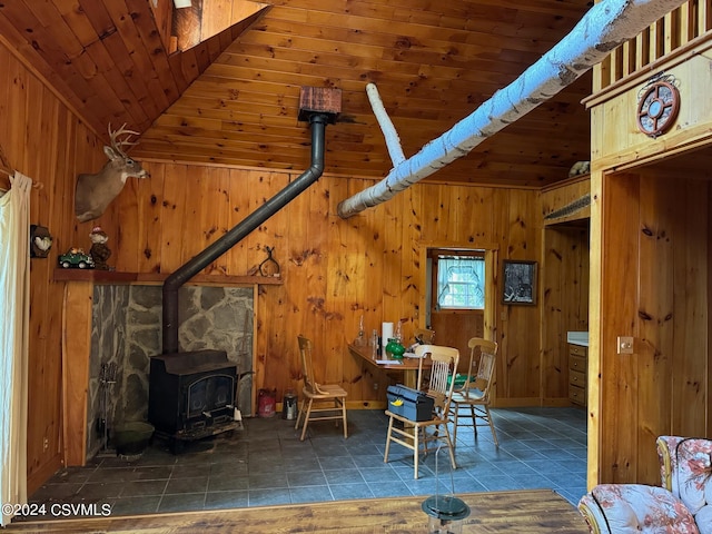 interior space featuring wood ceiling, wood walls, and a wood stove