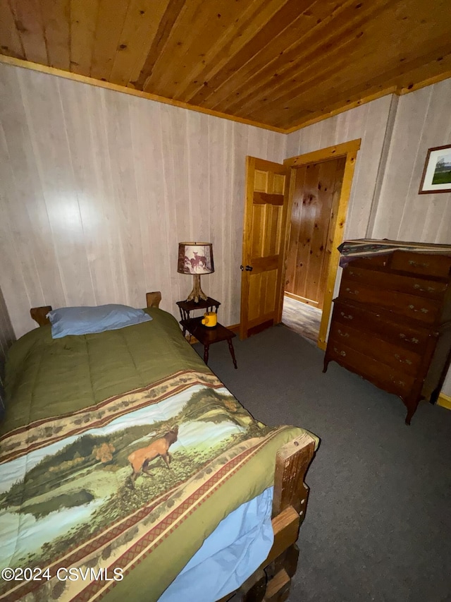 carpeted bedroom featuring wooden walls and wood ceiling