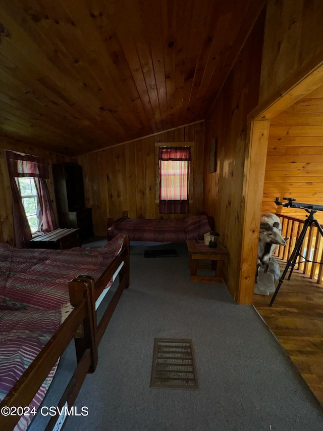 bedroom with wooden walls, lofted ceiling, wood ceiling, and hardwood / wood-style flooring