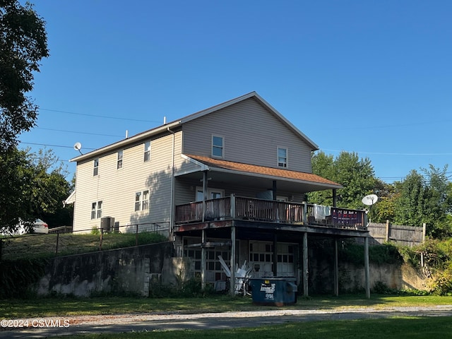 rear view of property featuring a yard and a deck