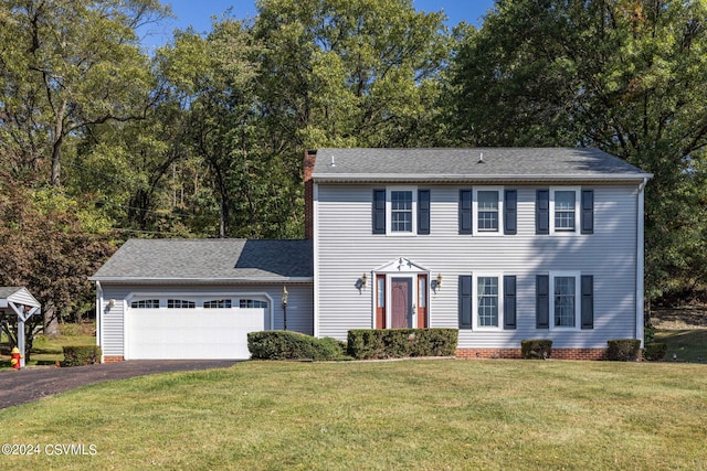 colonial house featuring a garage and a front lawn