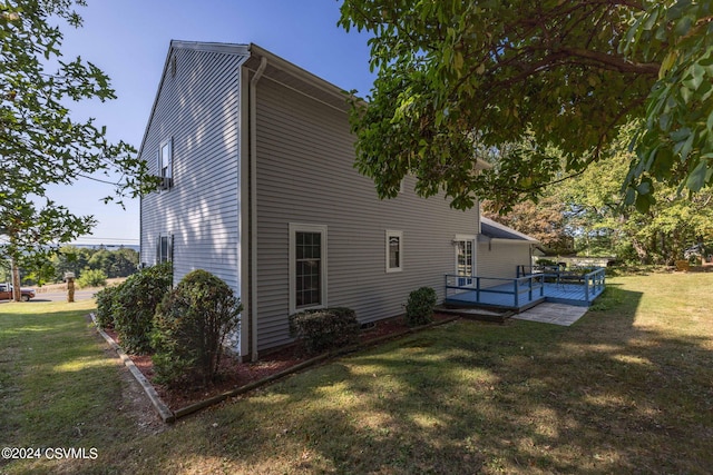 back of house with a wooden deck and a yard