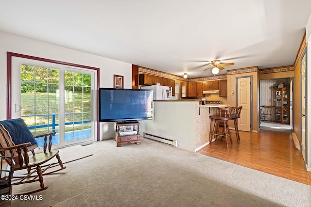 living room featuring a baseboard heating unit, ceiling fan, and hardwood / wood-style flooring