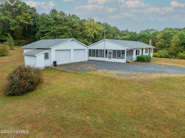 view of front facade featuring a front lawn, an outbuilding, a porch, and a garage