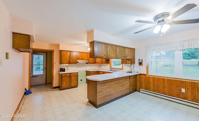 kitchen with ceiling fan, sink, kitchen peninsula, and a healthy amount of sunlight