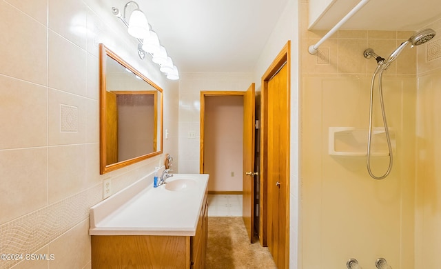 bathroom featuring vanity, tile walls, and a tile shower