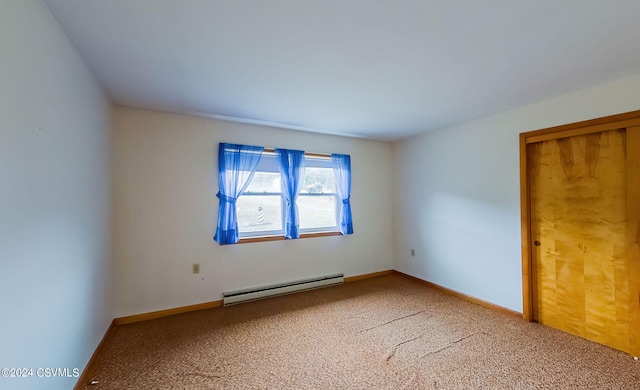 unfurnished room with baseboard heating and carpet flooring