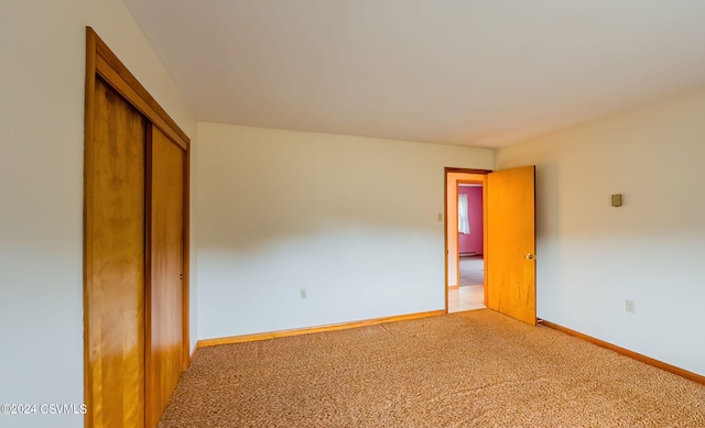 unfurnished bedroom featuring carpet floors and a closet