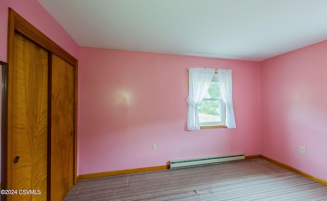 unfurnished bedroom with a closet, baseboard heating, and carpet flooring