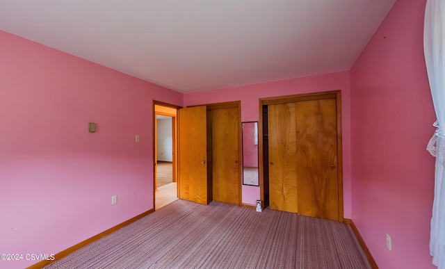 unfurnished bedroom with light carpet and a closet