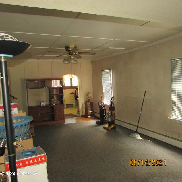 interior space featuring carpet flooring, ceiling fan, a healthy amount of sunlight, and a drop ceiling