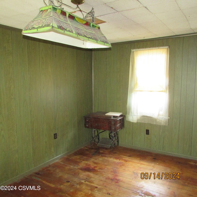 unfurnished room with wood walls and dark hardwood / wood-style floors