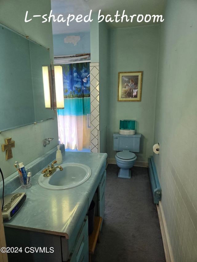 bathroom with tile walls, vanity, and toilet