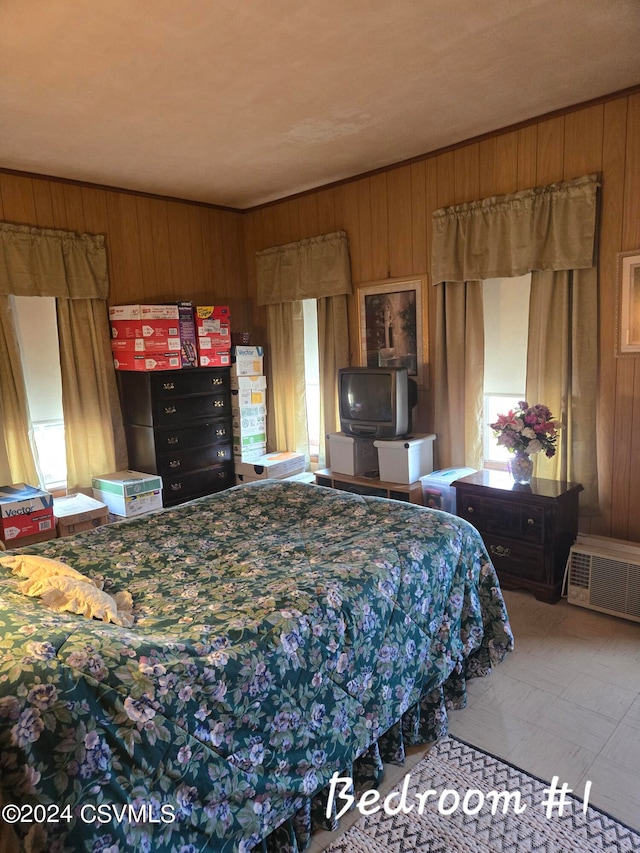 bedroom with wooden walls and multiple windows