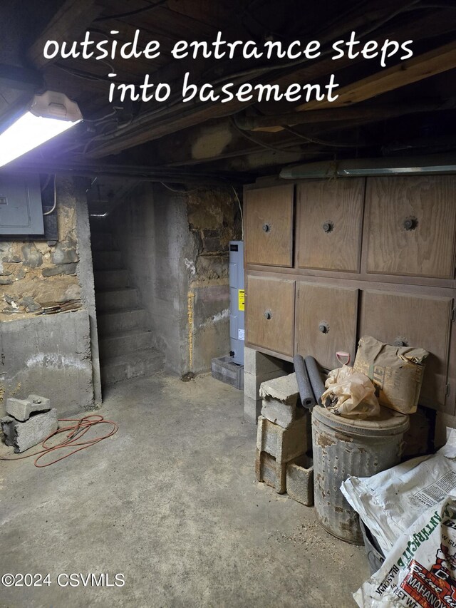 basement with electric water heater and electric panel