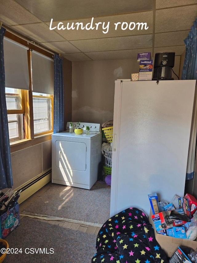 laundry area featuring carpet floors, a baseboard heating unit, and washer / dryer