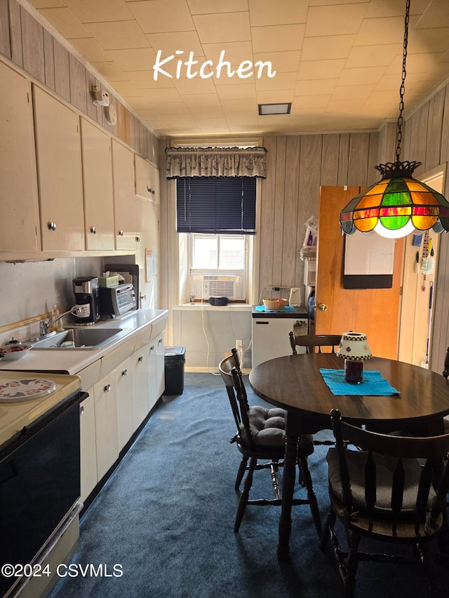 kitchen featuring electric stove, white cabinets, carpet flooring, decorative light fixtures, and sink