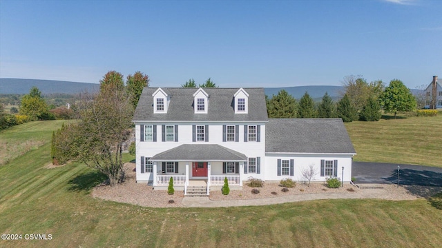 view of front of property featuring a mountain view, a front lawn, and a porch