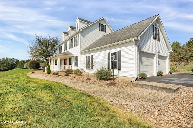 view of front facade with a porch, a garage, and a front yard