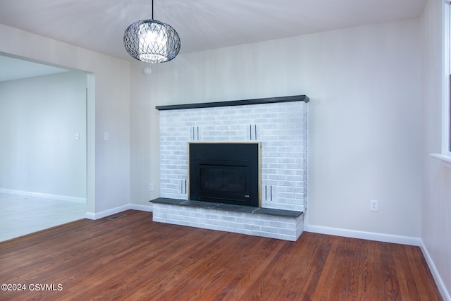 details with a notable chandelier, a fireplace, and hardwood / wood-style flooring