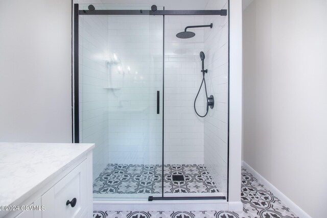 bathroom featuring vanity, tile patterned flooring, and a shower with shower door