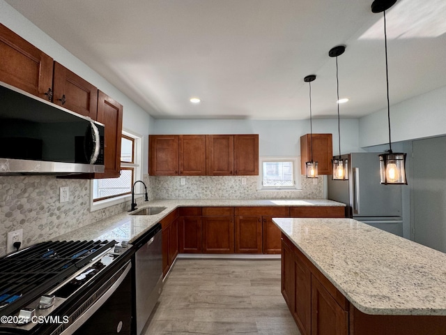 112 Green St, Edwardsville, PA 18704 - kitchen with light wood finished floors, a sink, tasteful backsplash, light stone counters, and appliances with stainless steel finishes