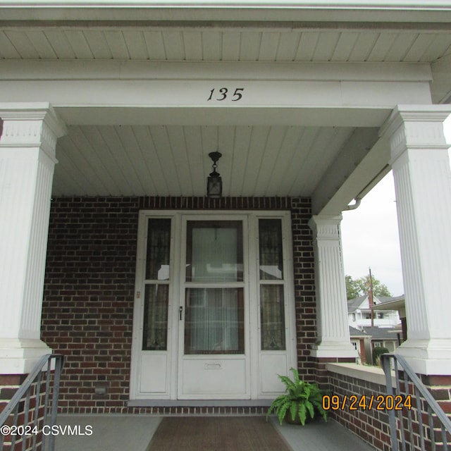 view of exterior entry featuring covered porch