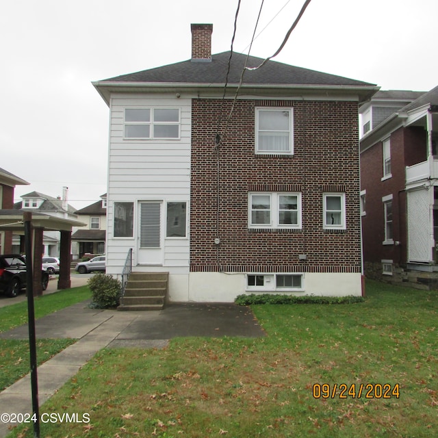 rear view of property with a lawn