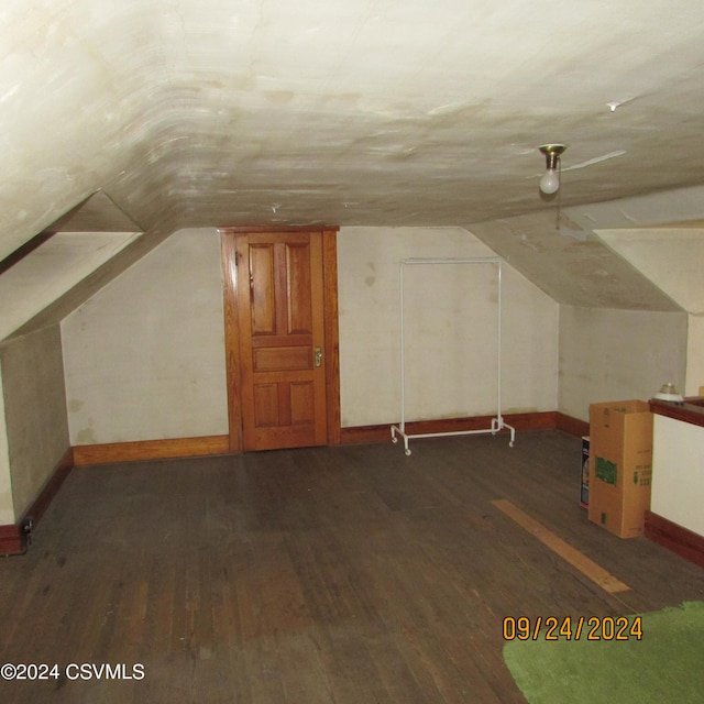 additional living space featuring vaulted ceiling and dark hardwood / wood-style floors