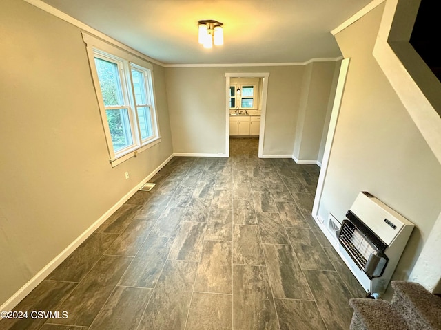 spare room with crown molding, dark hardwood / wood-style flooring, heating unit, and sink