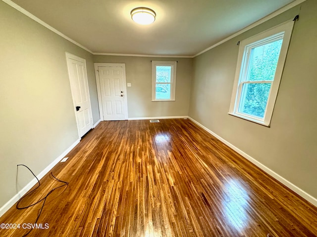 unfurnished room with hardwood / wood-style flooring and crown molding