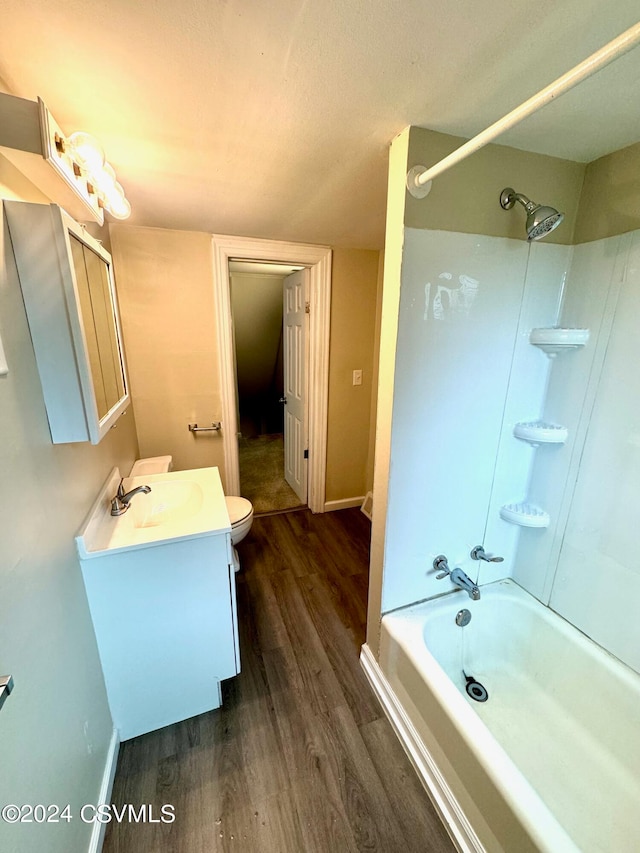 full bathroom featuring wood-type flooring, vanity, bathtub / shower combination, and toilet