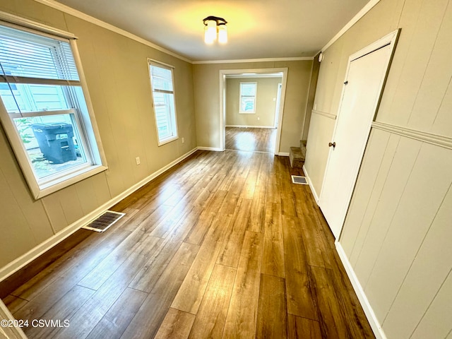 hallway with crown molding, hardwood / wood-style floors, and a wealth of natural light