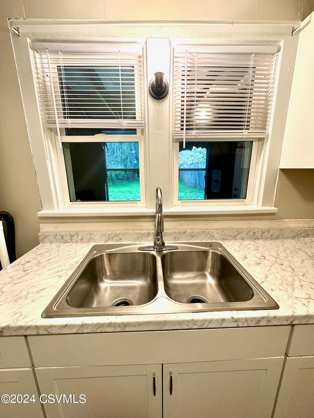 details featuring white cabinetry and sink