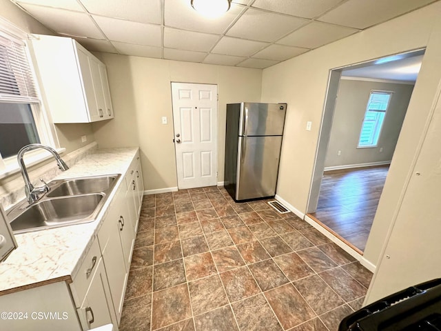 kitchen featuring dark hardwood / wood-style floors, sink, white cabinets, stainless steel refrigerator, and a drop ceiling