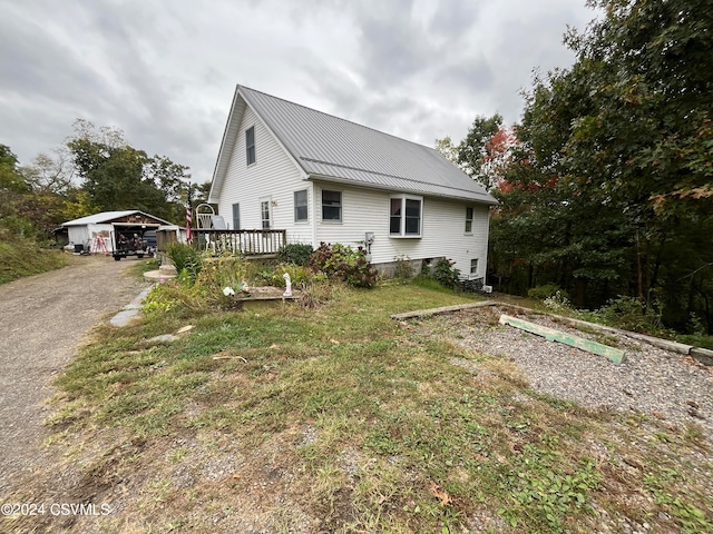 view of home's exterior with a yard, metal roof, and an outdoor structure