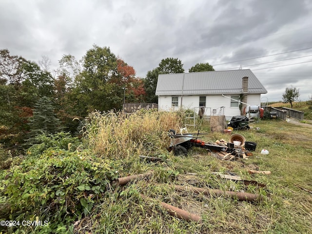 rear view of property featuring fence and metal roof