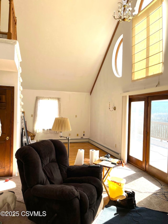 living room with high vaulted ceiling, a chandelier, baseboard heating, and wood finished floors