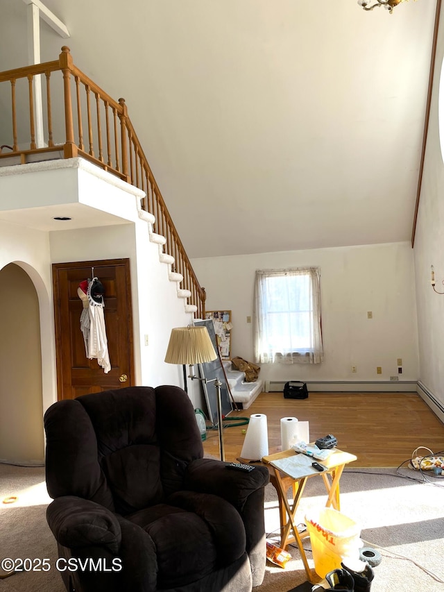 living area featuring light wood-style floors, lofted ceiling, arched walkways, and stairway