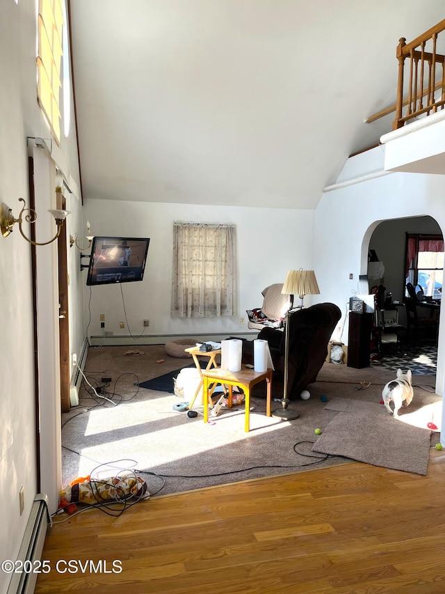 interior space with a baseboard radiator, high vaulted ceiling, arched walkways, and wood finished floors