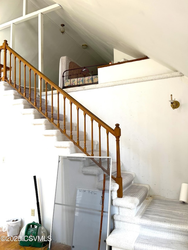 staircase with high vaulted ceiling