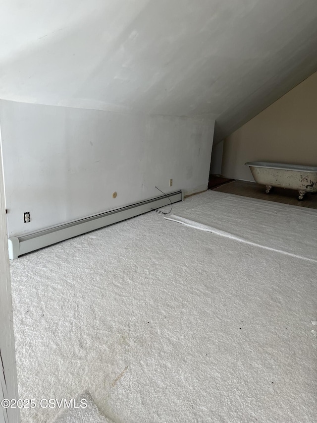 bonus room with a baseboard heating unit, carpet, and lofted ceiling