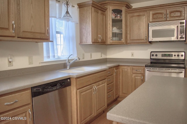 kitchen with hanging light fixtures, sink, and stainless steel appliances